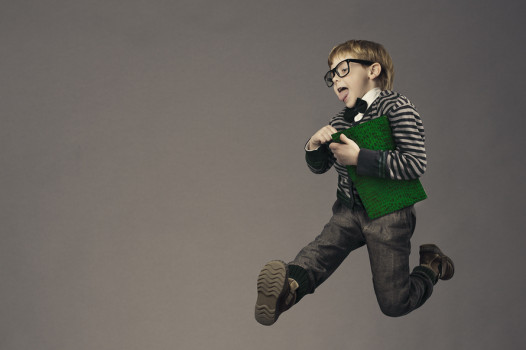 child running back to school funny kid portrait jumping smart schoolboy with glasses and book
